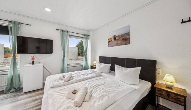 Cozy double room, flat-screen TV, and modern bathroom with shower. Ideal for couples and short stays – enjoy a relaxed atmosphere with warm wood accents and coastal charm.